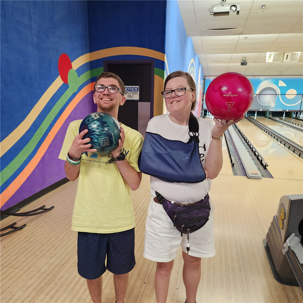  Two adults holding bowling balls